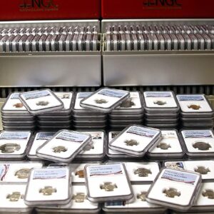 Stacks of collectible coins in plastic holders displayed on a table.